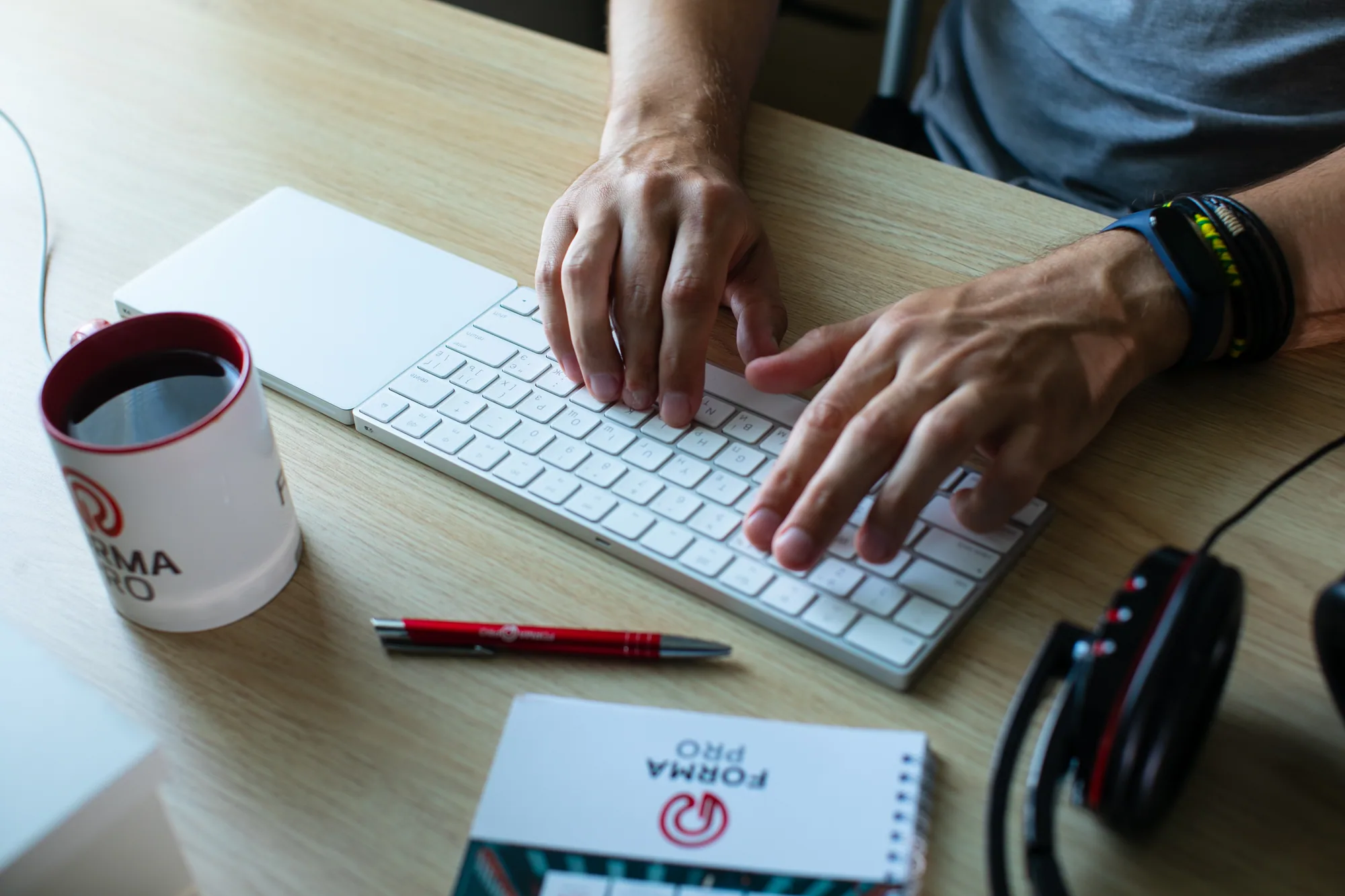 Hands working at a keyboard in a product engineering workspace.